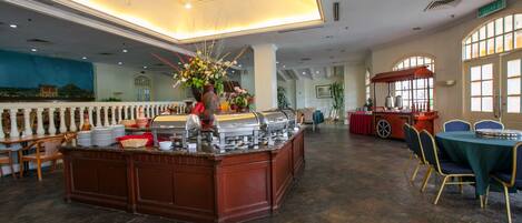A buffet area with a central island, seating arrangements, and a large window providing natural light.
