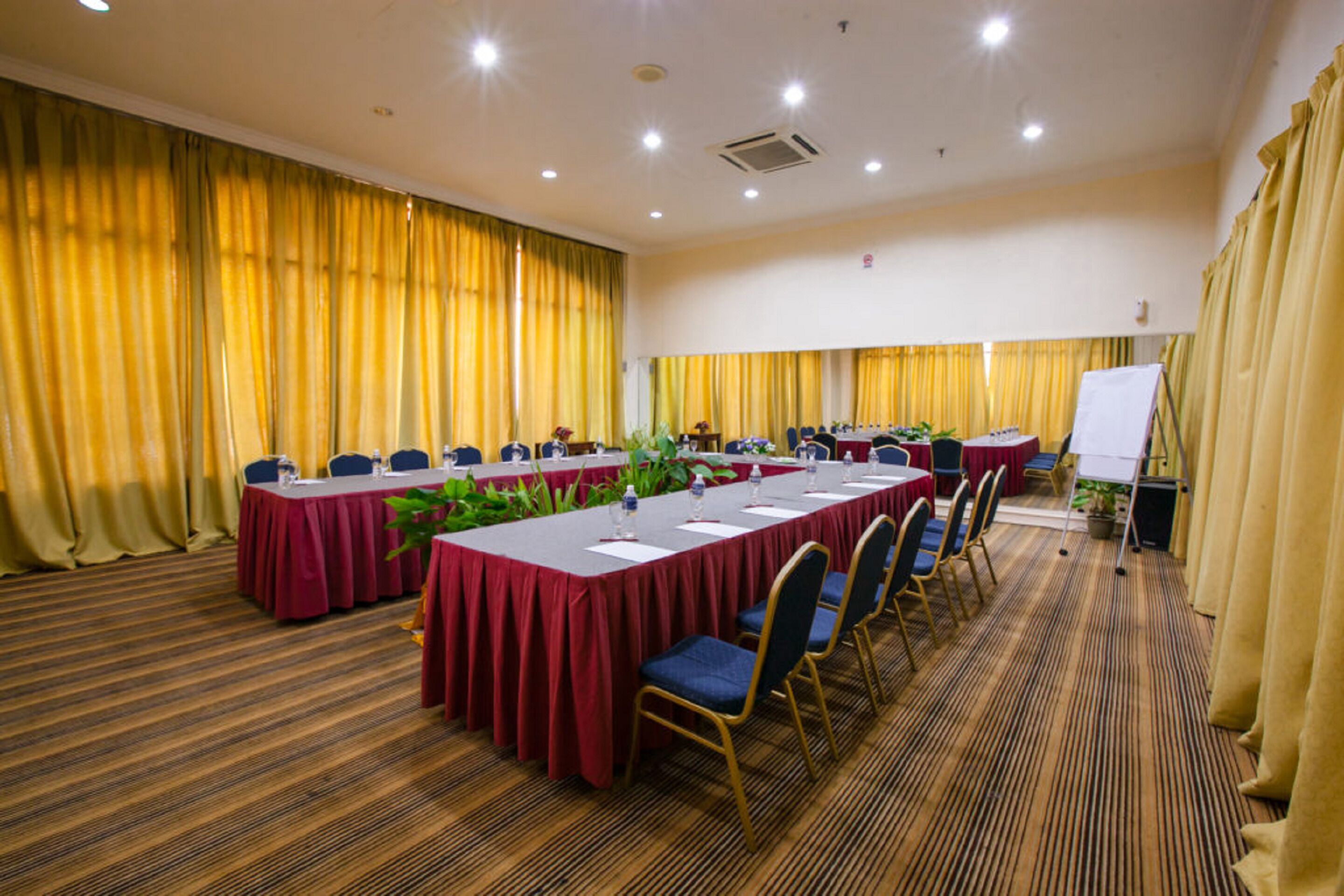 A conference room with multiple tables, chairs, and a whiteboard.