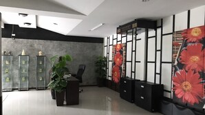 Un espace de bureau moderne doté d'un comptoir d'accueil, de vitrines et de panneaux décoratifs à motifs floraux.