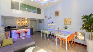 A modern interior with a dining area, kitchen, and seating space. - Shell Hotel (Hengchun)