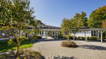 Stroll through the serene courtyard, surrounded by lush gardens and a traditional walkway.