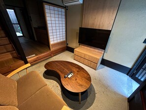 Relax in this stylish living room with a sofa, flat-screen TV, and sliding shoji screen door.