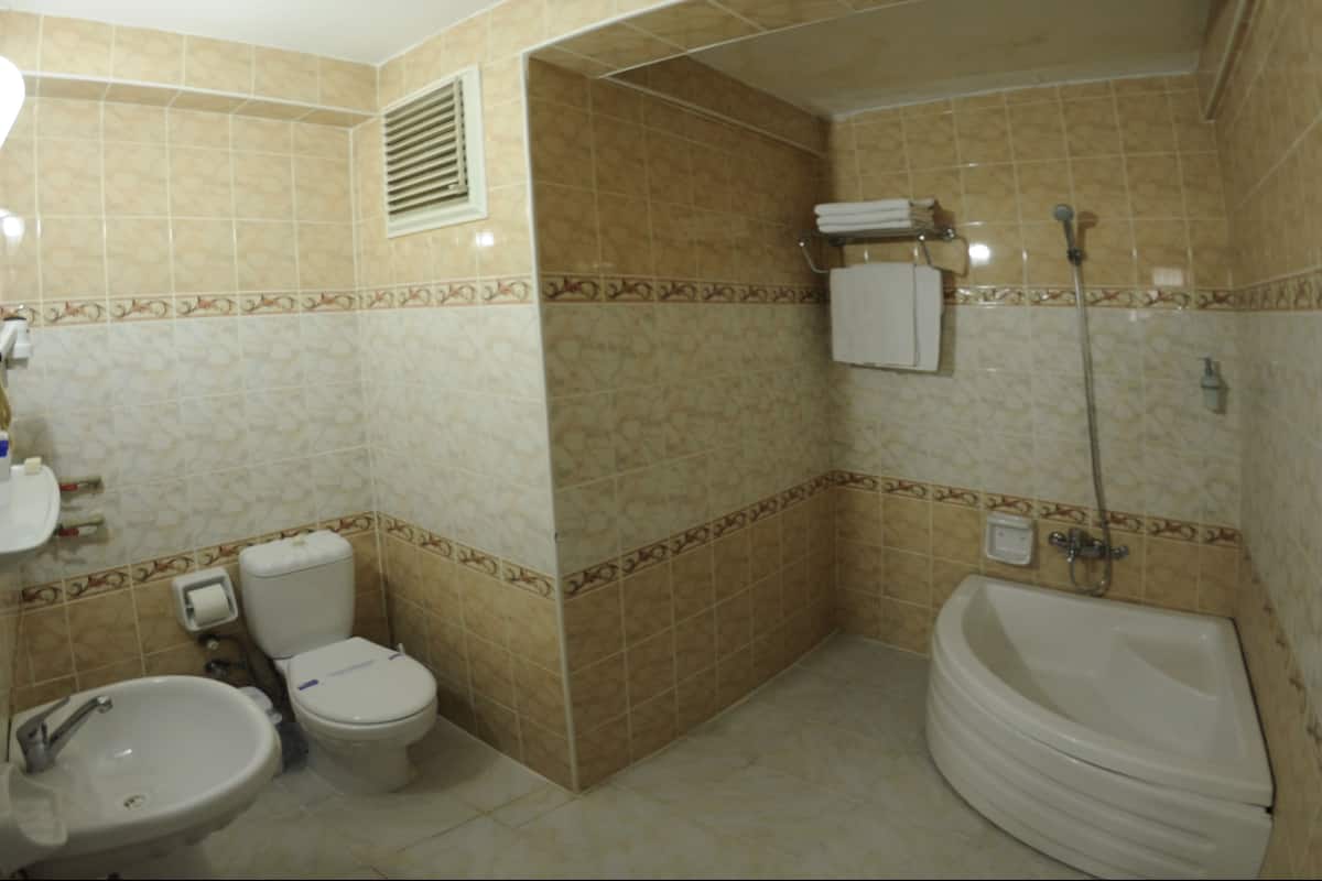 Habitación cuádruple Premium | Baño | Regadera, amenidades de baño gratuitas, secadora de cabello, pantuflas