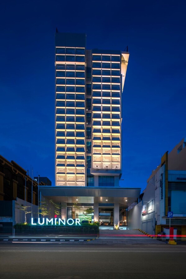 A modern hotel with a prominent entrance and a name sign. - Luminor Hotel Pecenongan Jakarta by WH (Jakarta)