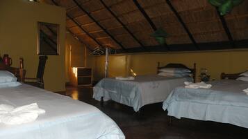 A hotel room with two beds, a wooden ceiling, and a framed picture on the wall.