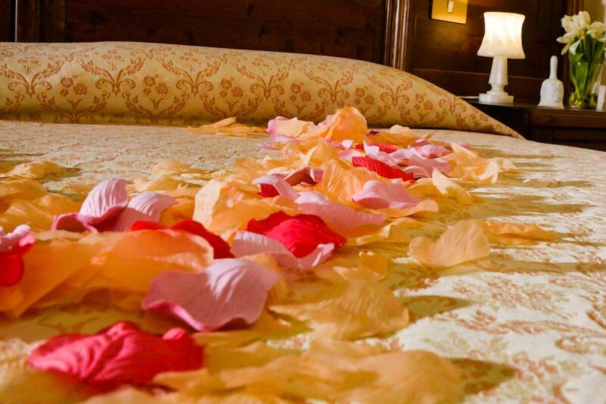 Un lit recouvert de pétales de rose.
