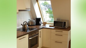 Eine Küche mit Backofen, Wasserkocher, Toaster und Mikrowelle.
