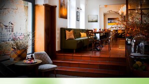 Ein gemütliches Interieur mit einer Couch, Sesseln, einem Esstisch und einer Bar.