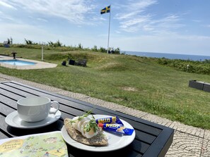 A table with a plate of food, a cup, and a map.