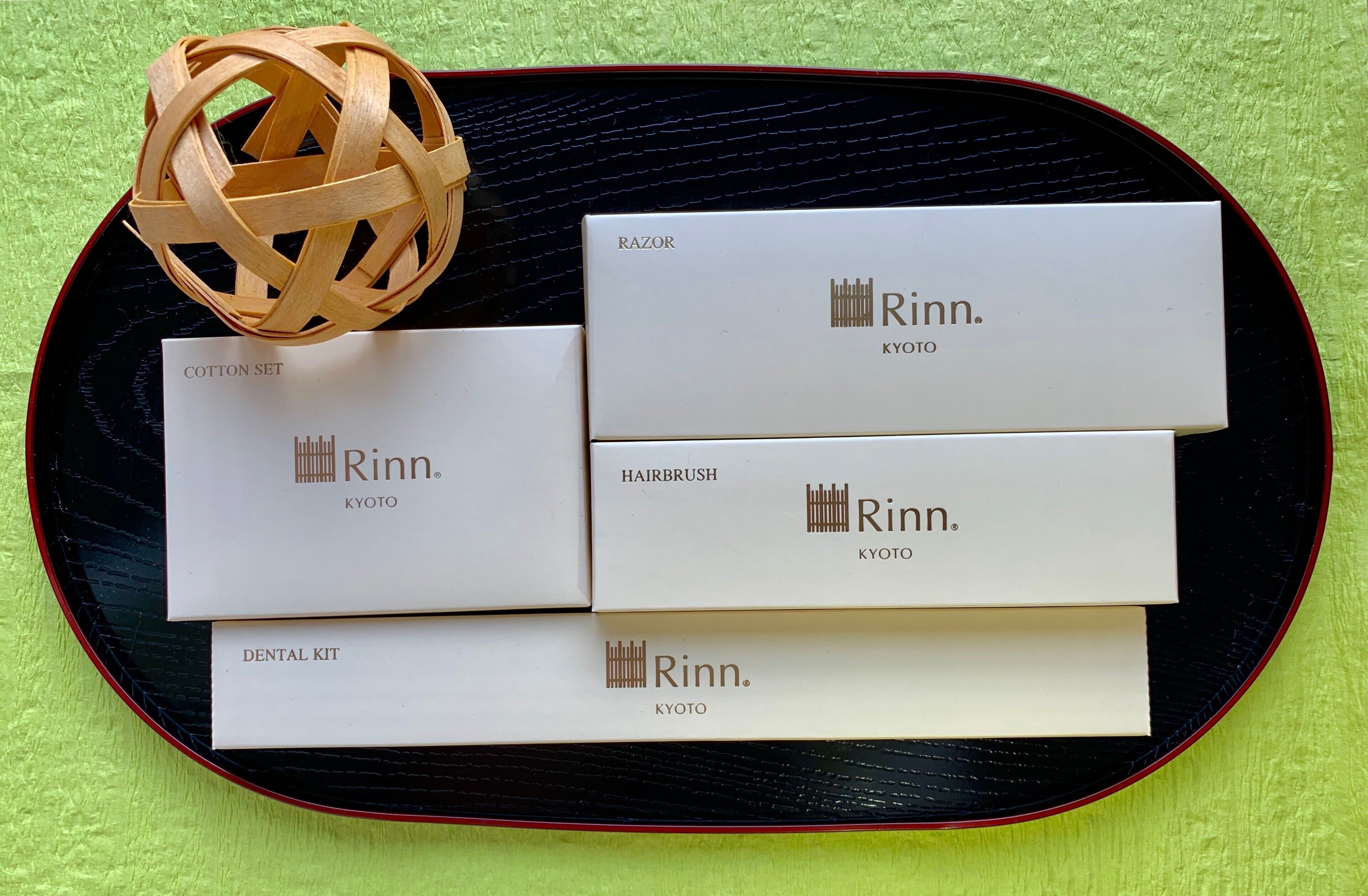 Een dienblad met vier dozen met de tekst 'Rinn. KYOTO' en een geweven bal.