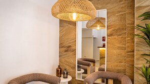 Un baño moderno con un espejo grande, dos lámparas de mimbre y una planta.