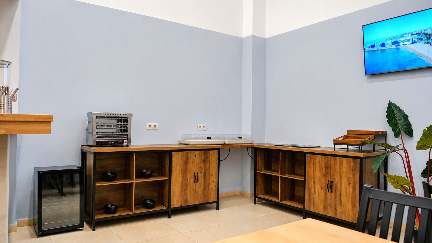 Una cocina compacta con electrodomésticos integrados, armarios de madera y un refrigerador pequeño.
