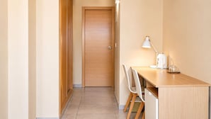 A hallway leading to a room with a wooden door, a desk with a lamp, and a chair. - Nuvi Mercado (Alicante)