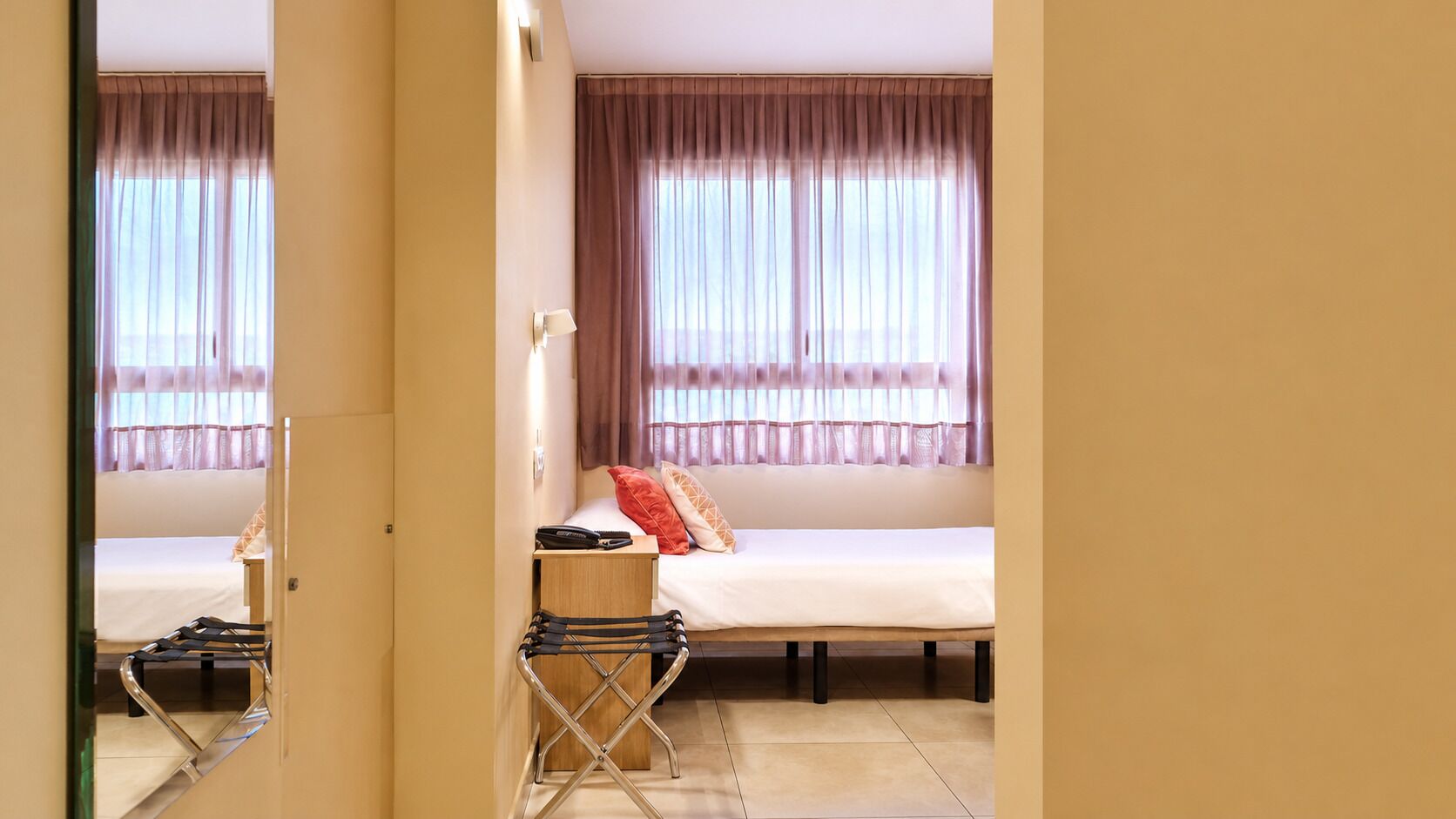 Una habitación de hotel con una cama, un escritorio y una silla.