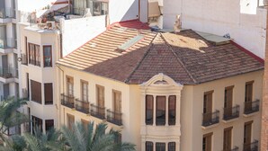 Un edificio de varios pisos con un patio central, con balcones y una tienda General Optica en la planta baja.