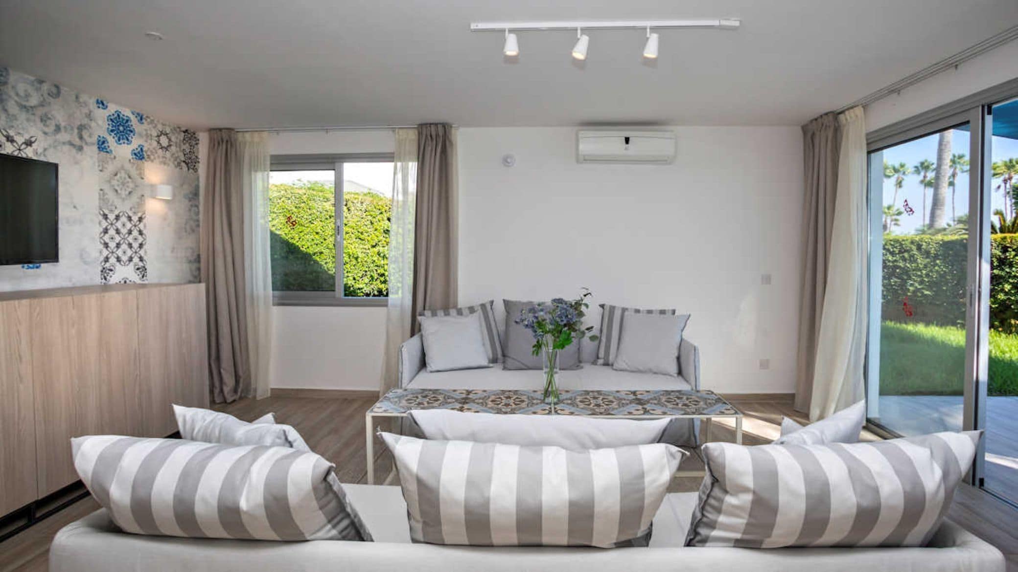 Une chambre avec un lit, un canapé, une télévision et une fenêtre donnant sur un paysage verdoyant.