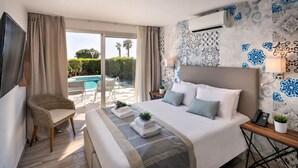 Une chambre d’hôtel équipée d’un lit, d’une chaise, d’un bureau, d’un téléphone et offrant une vue sur une piscine.