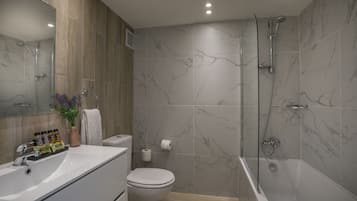A modern bathroom with a bathtub, shower, toilet, and sink.