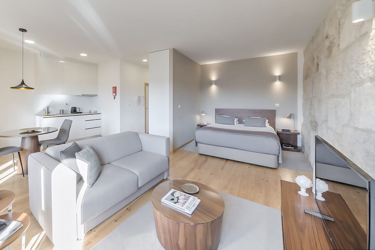 A modern, well-lit bedroom with a large bed, a bedside table, and a nightstand.