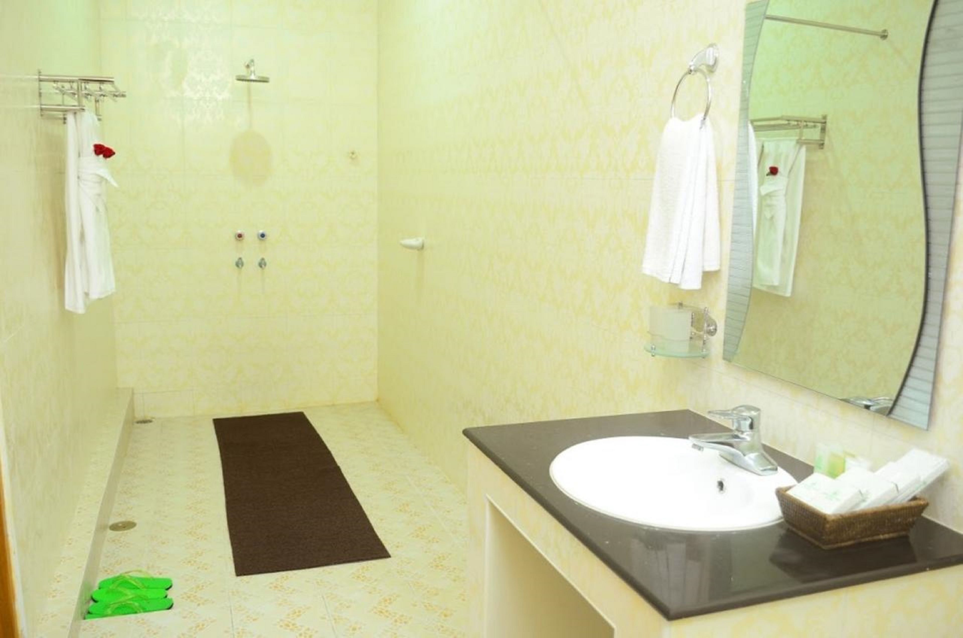 A bathroom with a shower, a sink, and a mirror.