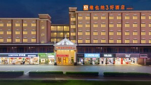 Un hotel con diversi piani, un ingresso centrale e vari negozi a livello strada.