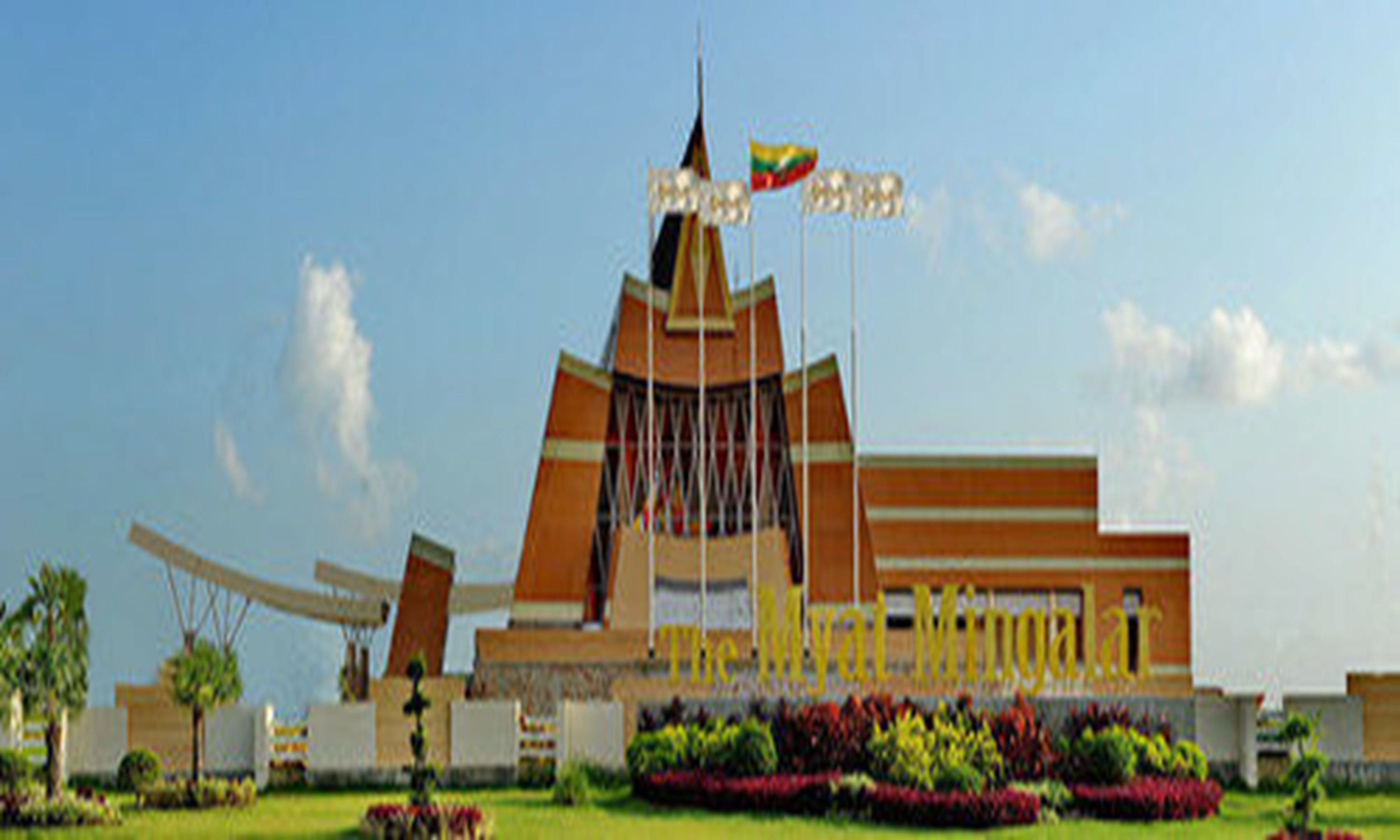 A large, modern building with a prominent tower and multiple flags.