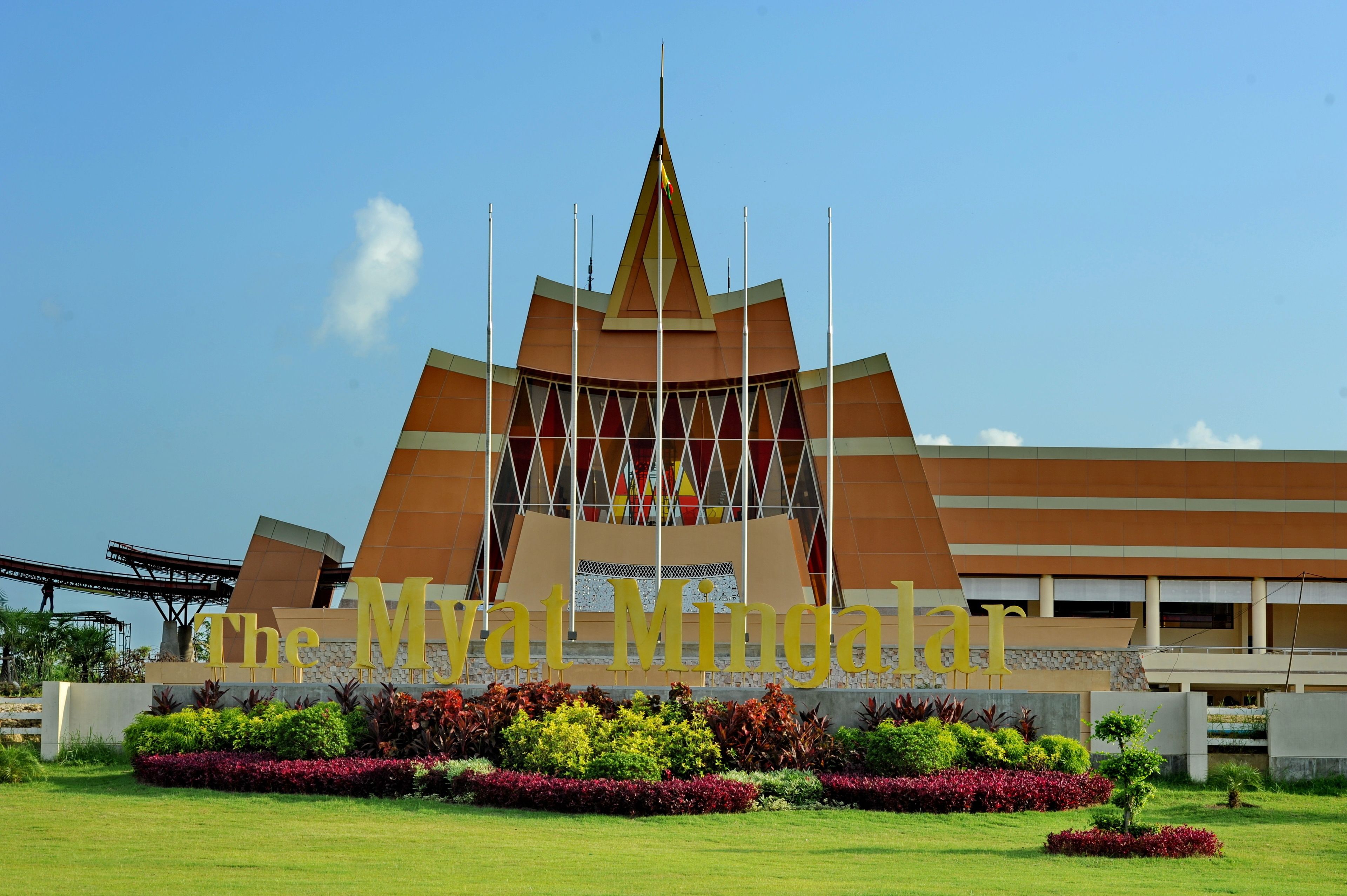 Un edificio moderno con un techo triangular distintivo y un letrero que dice "The Mya Minga".