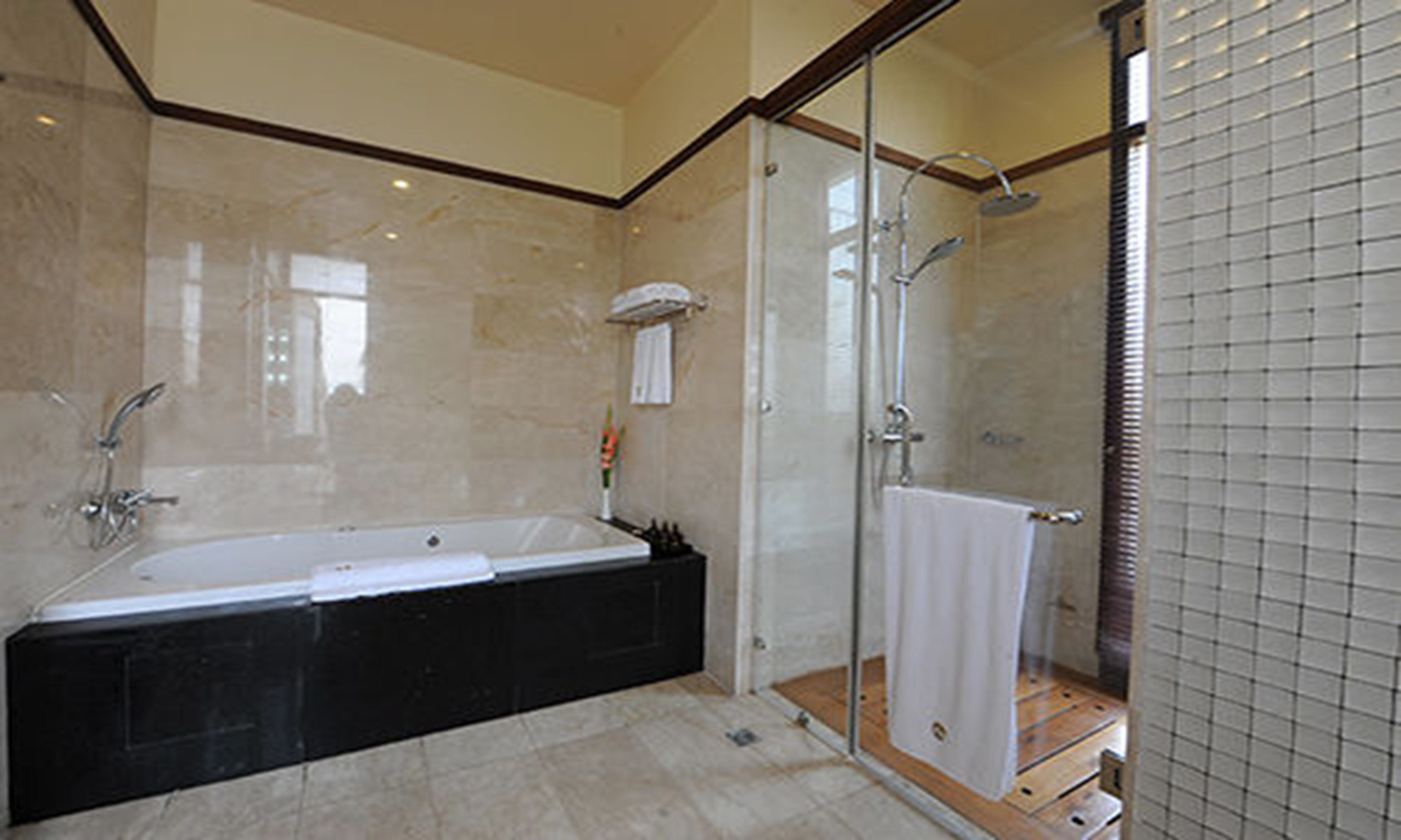 Un baño moderno con una bañera grande, cabina de ducha con vidrio y zona de ducha con azulejos.