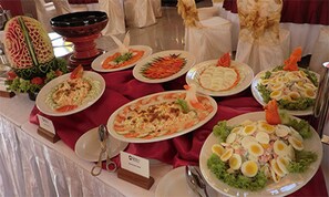 A buffet table with various dishes, including salads, pasta, and seafood.