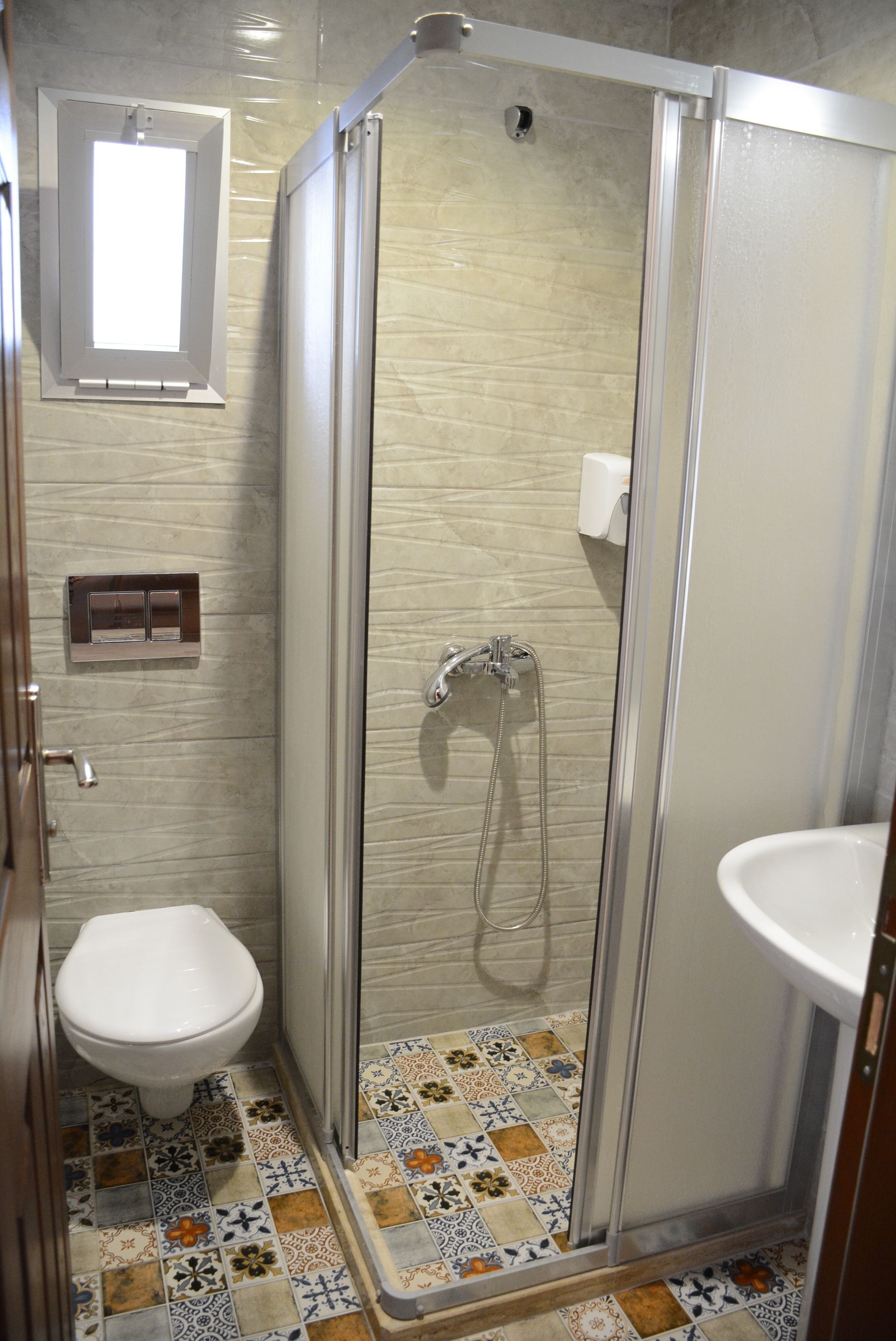 Un baño con cabina de ducha, inodoro y lavabo.