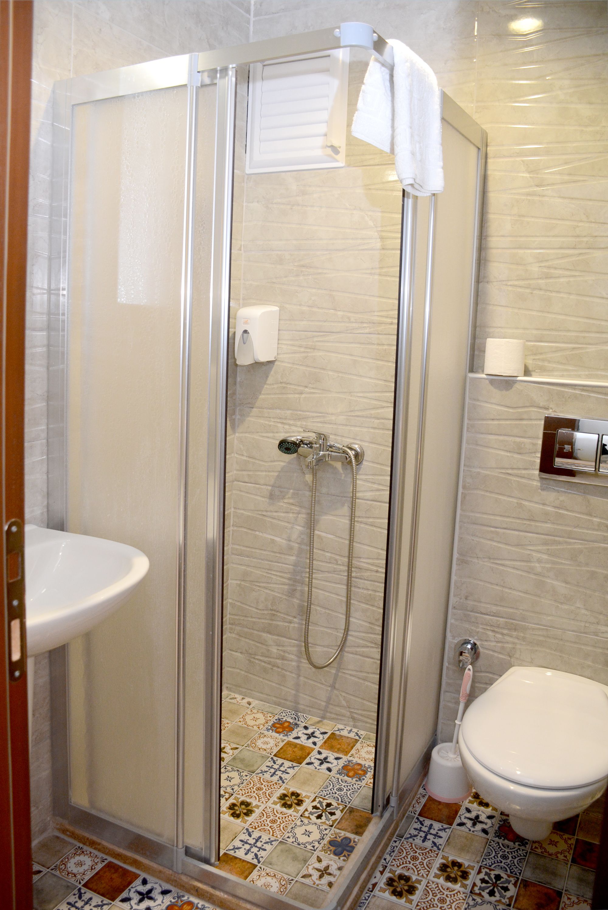 Un baño con ducha de vidrio, inodoro y lavabo.