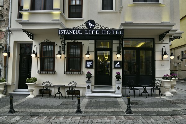 The exterior of the Istanbul Life Hotel with a sign above the entrance, a black door, and outdoor seating with potted plants. - Istanbul Life Hotel - Adults Only (Istanbul)