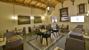 A conference room with tables and chairs, a projector screen, and a painting on the wall. - Istanbul Life Hotel - Adults Only (Istanbul)