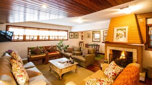 Una sala de estar acogedora con chimenea, asientos cómodos y televisión.