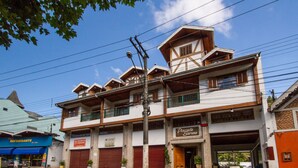 Un edificio de dos pisos con un letrero que dice 'Pousada Serena' y un restaurante llamado 'El Restaurante'.