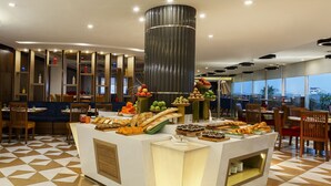 A breakfast buffet with various food items and a modern interior design.