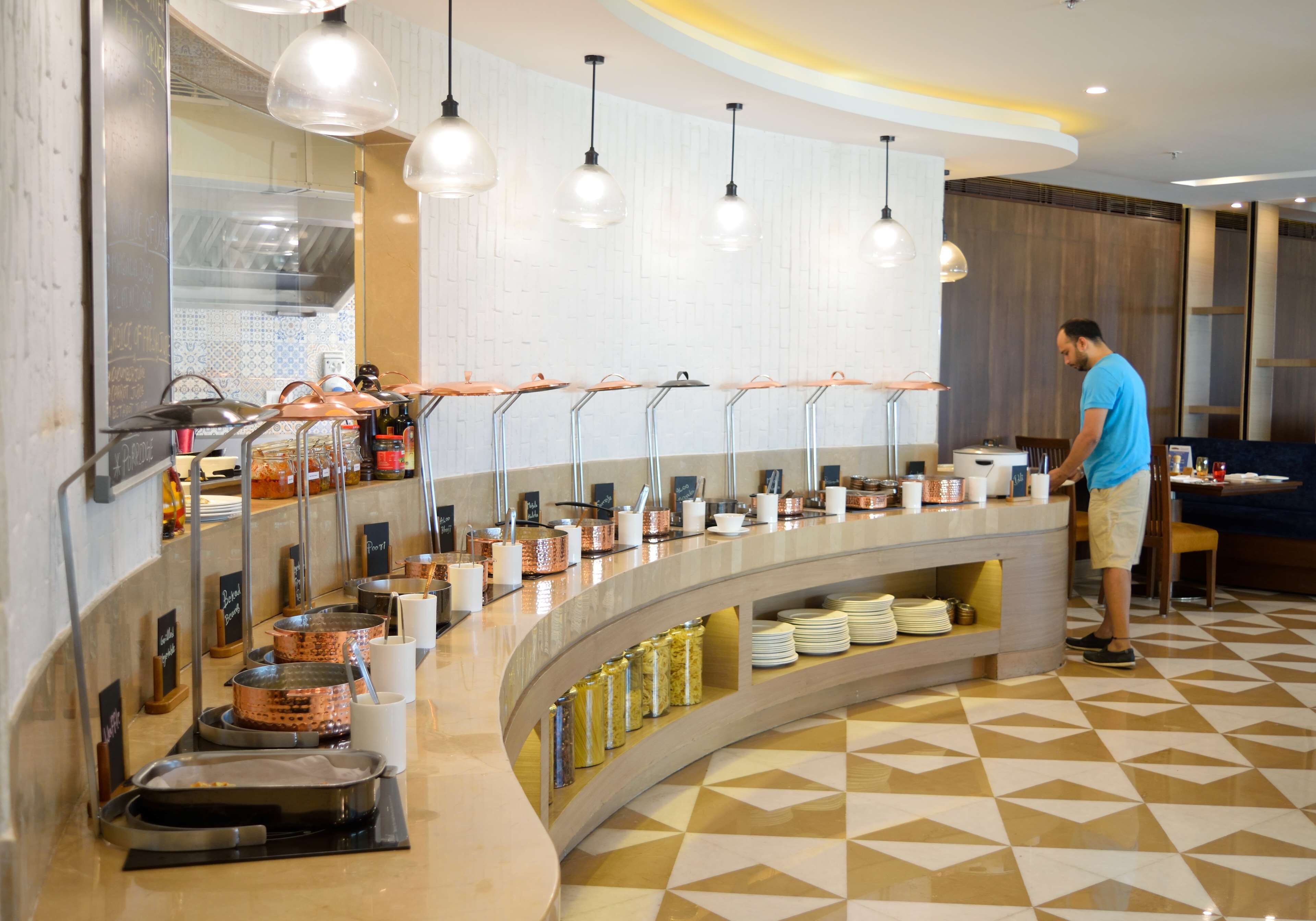 A buffet setup with various food containers and utensils.