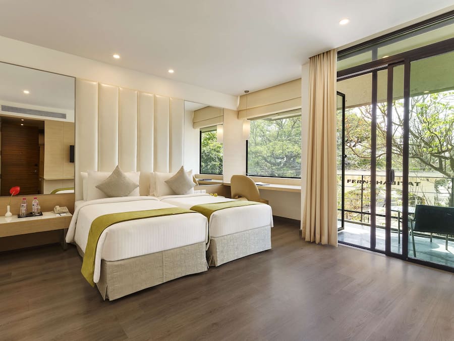 Een moderne hotelkamer met een groot bed, een bureau en uitzicht op de omgeving.