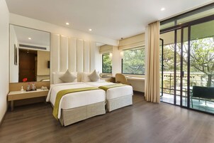 Habitación de hotel moderna con una cama grande, un escritorio y vistas al exterior.