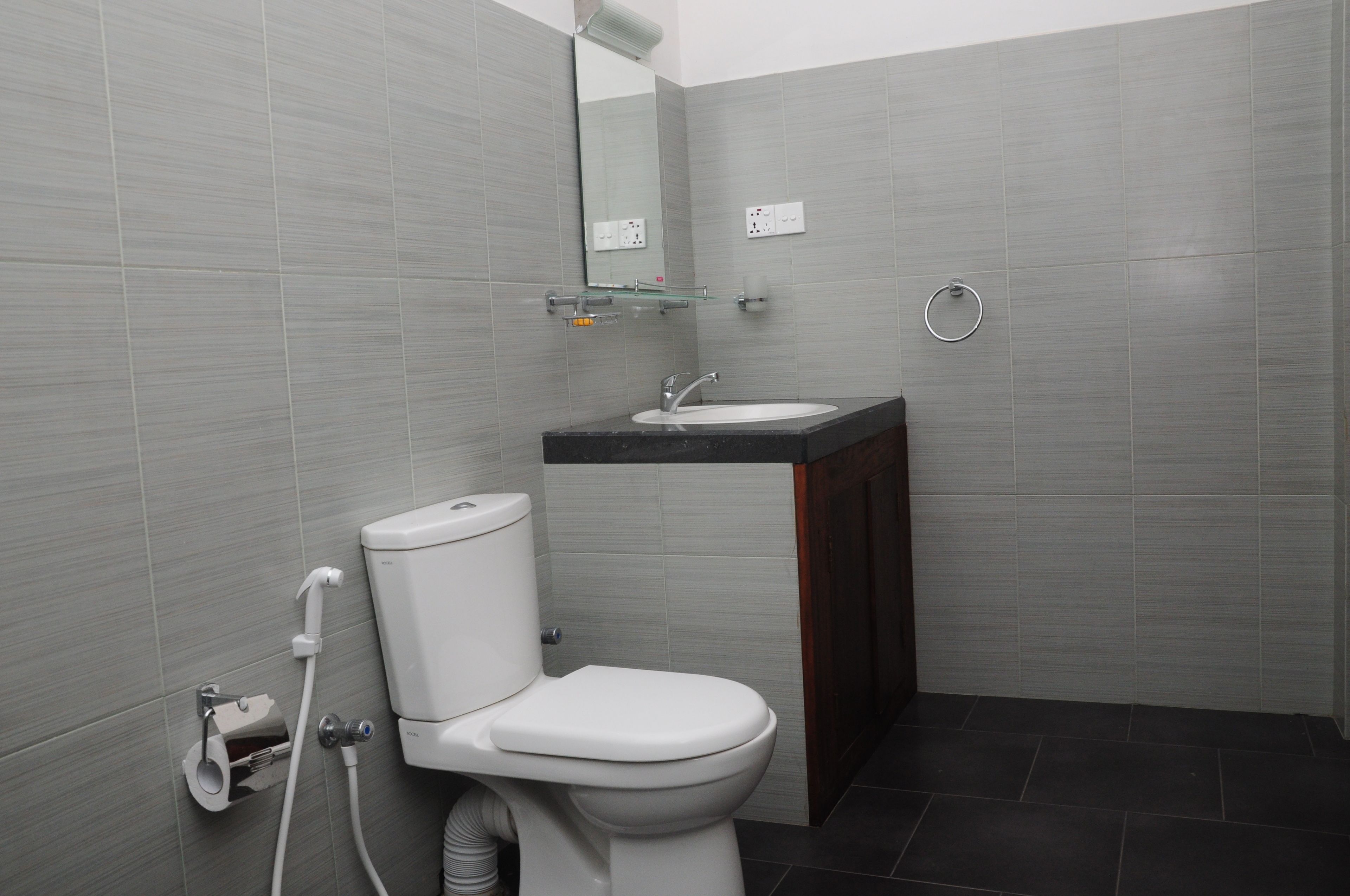 Un baño moderno con inodoro, lavamanos y espejo.