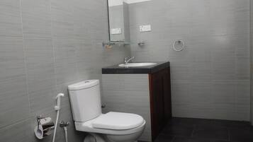 Un baño moderno con inodoro, lavamanos y espejo.