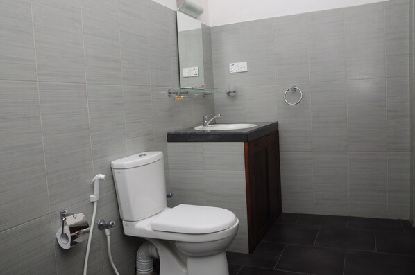 Une salle de bain moderne avec des toilettes, un lavabo et un miroir.