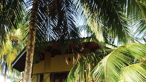 A two-story building with a balcony, surrounded by palm trees. - Traveller's Home Hotel (Thissamaharama)