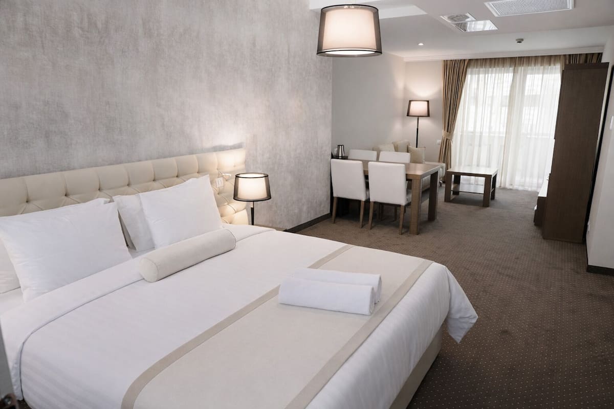Une chambre d’hôtel avec un grand lit, un bureau et une chaise.