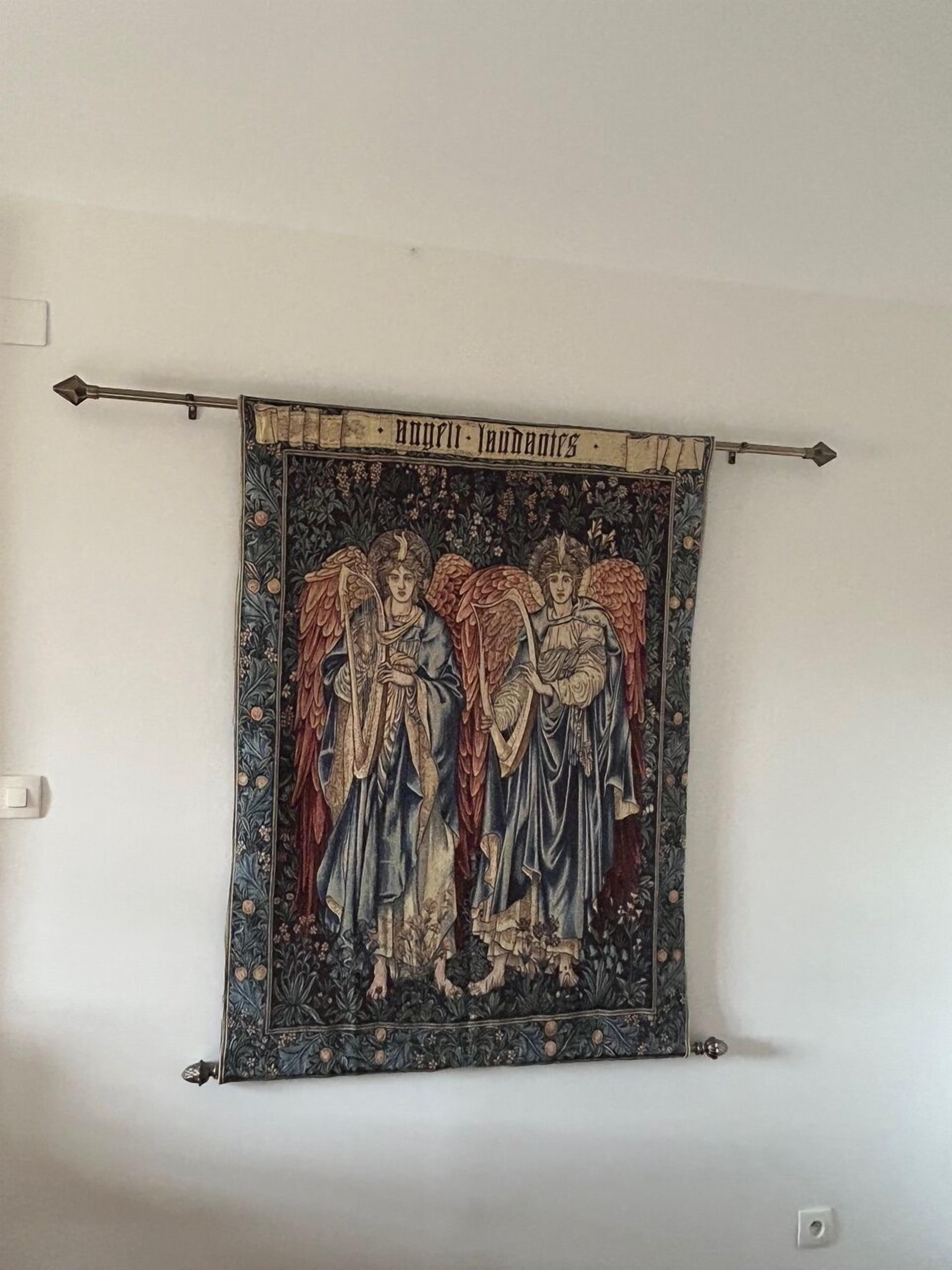 A tapestry with a medieval design hanging on a wall.