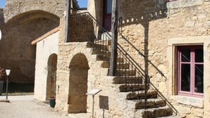 Un edificio de piedra con una torre, una escalera y arcos.