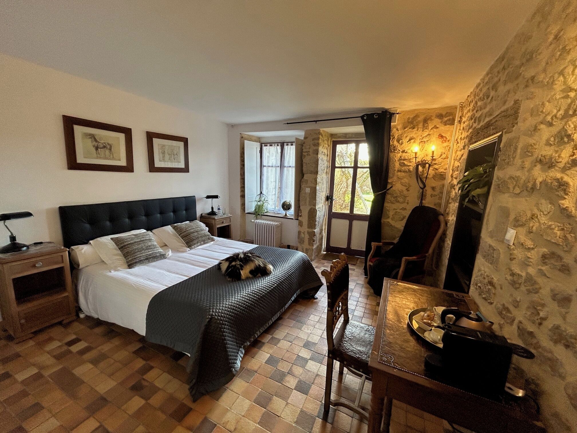 A bedroom with a bed, bedside tables, a desk, and a chair.