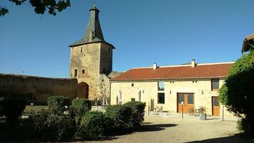 Un edificio histórico con una torre y un patio.