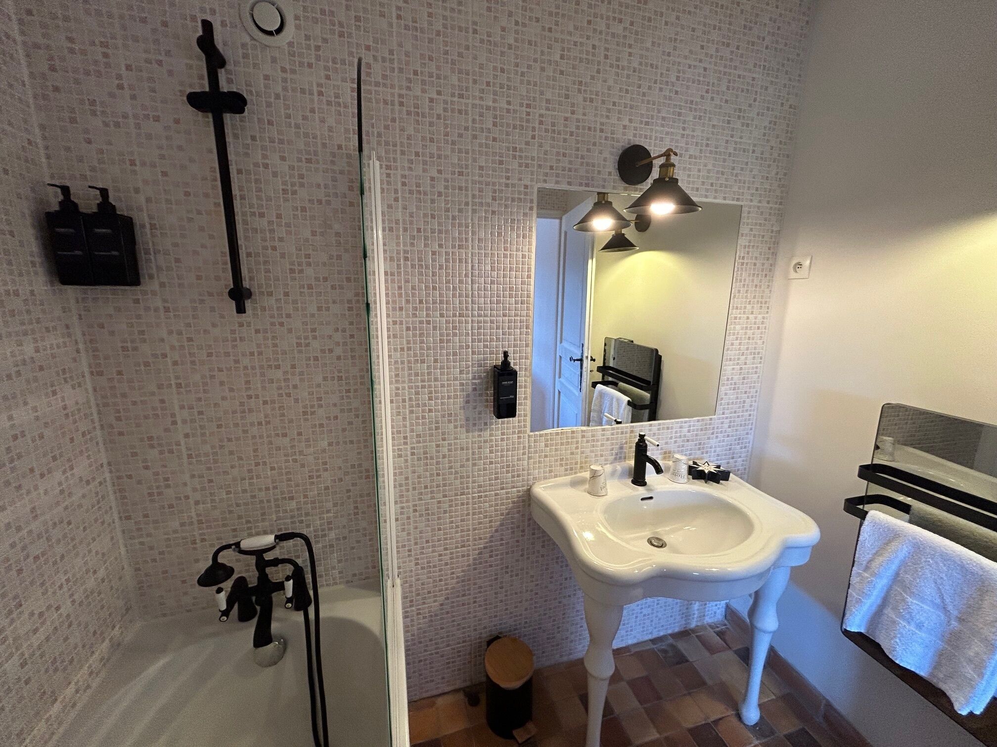 Un baño con ducha, lavamanos y espejo.