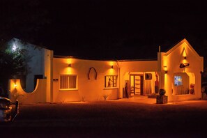 A modern building with a curved facade, illuminated windows, and a well-lit entrance.